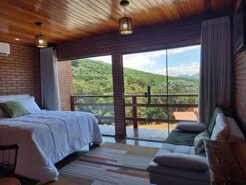 1 dormitorio con 1 cama y balcón con vistas. en Vivendas Canaã, en Espera Feliz