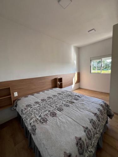 a bedroom with a large bed with a flowered blanket at Skyhouse in Boituva