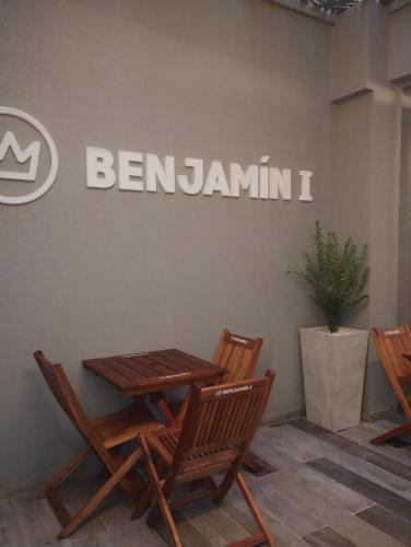 a wooden table and chairs in front of a sign at Benjamín I in San Salvador de Jujuy