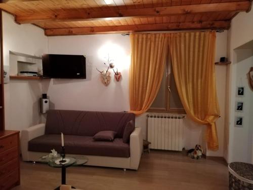 a living room with a couch and a window at Cá del Manöl in Villa di Tirano