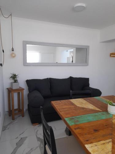 a living room with a couch and a wooden table at Arenales 5 in Azul
