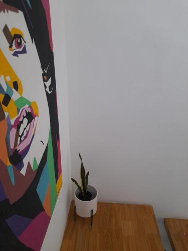 a plant in a pot next to a painting at Arenales 5 in Azul