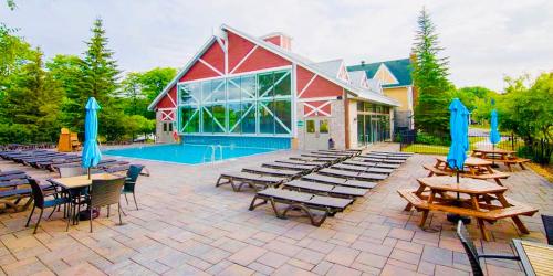 a patio with tables and chairs and a pool at Hillside Haven: Carriage Club Resort Retreat in Edgar