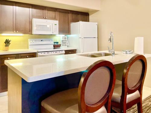 a kitchen with a counter with two chairs and a sink at Hillside Haven: Carriage Club Resort Retreat in Edgar