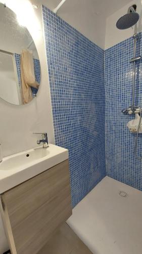 W łazience znajduje się umywalka, lustro i niebieskie kafelki. w obiekcie Ocean view with terrace w mieście Santa Cruz de Tenerife