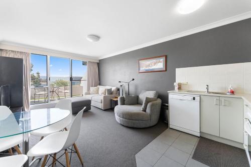a living room with a kitchen and a dining room at Horizons 414 - Deluxe Lake Front Studio l Pool l Tennis l WiFi in Jindabyne