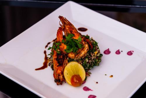 a white plate with a fish dish with a lemon at Sonesta Nouba Hotel Aswan in Aswan