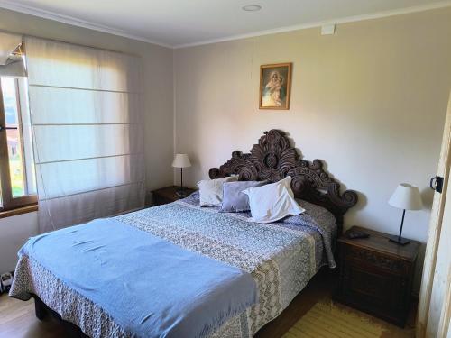 a bedroom with a large bed with a blue comforter at Casa Bella Vista Futrono in Futrono