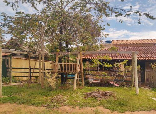 una panchina di legno di fronte a una casa di Casa Jasmim a Cavalcante