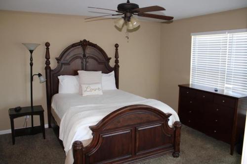 a bedroom with a large wooden bed and a ceiling fan at House # 49 No Wake Zone (no pets) in Centre
