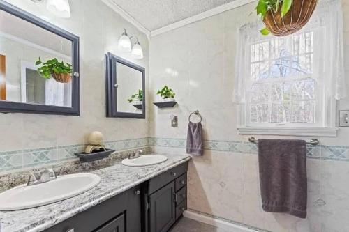 a bathroom with two sinks and a window at Alpine Oasis - House in the Adirondacks close to Lakes, Golf, Skiing and so much more! 