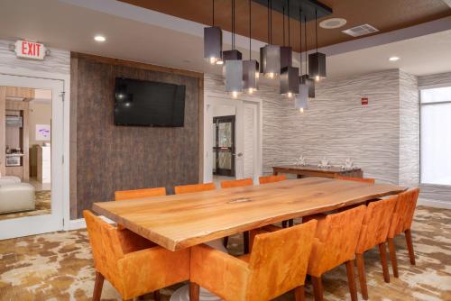 a dining room with a large wooden table and chairs at Hilton Garden Inn Phoenix Airport in Phoenix