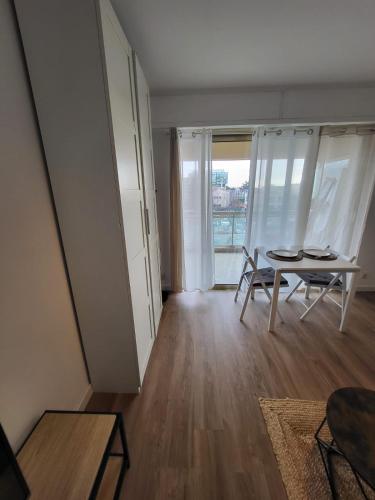 un salon avec une table et une fenêtre dans l'établissement Charmant studio, à Saint-Laurent-du-Var
