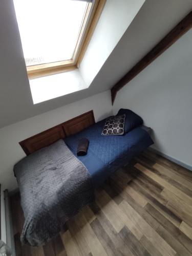 een bed in een kamer met een groot raam bij Le Faubourg in Saint-Quentin