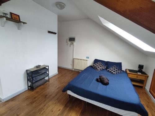 een slaapkamer met een blauw bed op een zolder bij Le Faubourg in Saint-Quentin