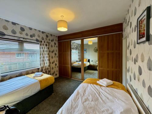 um quarto com 2 camas e um quarto com uma janela em Freeston House - Great for Contractors or Family Holidays em Cleethorpes