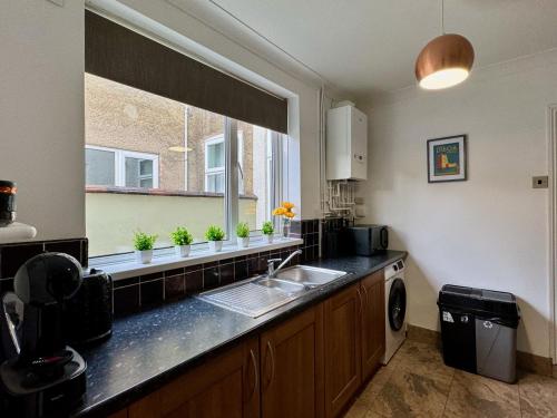 uma cozinha com um lavatório e uma janela em Freeston House - Great for Contractors or Family Holidays em Cleethorpes