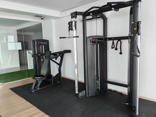 a gym with a treadmill and a chair in a room at Homestay Pangsapuri Simfoni 3BR 7Pax Kuah Langkawi in Kuah