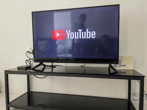 a television on a stand with a youtube sign on it at Homestay Pangsapuri Simfoni 3BR 7Pax Kuah Langkawi in Kuah