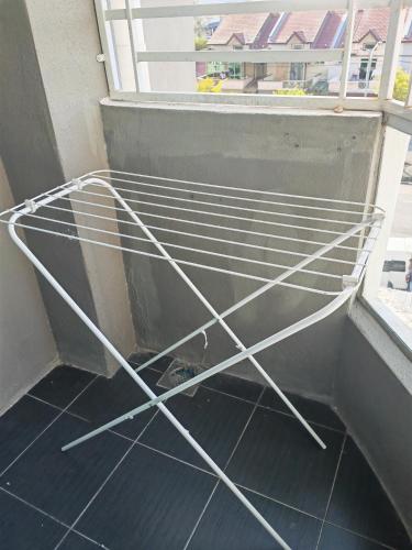 a metal bed on the floor of a balcony at Homestay Pangsapuri Simfoni 3BR 7Pax Kuah Langkawi in Kuah