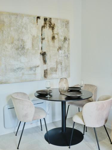 une salle à manger avec une table noire et quatre chaises dans l'établissement Bel appart au charme parisien, pour 6 personnes, à Paris