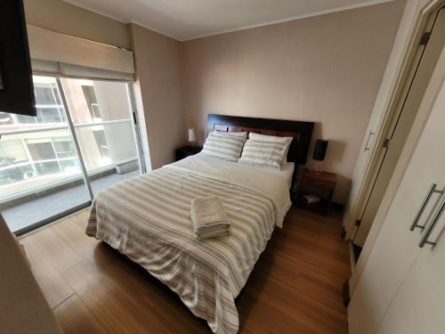 um quarto com uma cama grande e uma janela grande em Espacio Luxury Apartments-San Martín em Lima