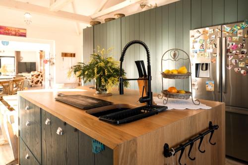 a kitchen counter with a sink and a refrigerator at Quinta da Cris (Private Beach Retreat) in Costa Nova