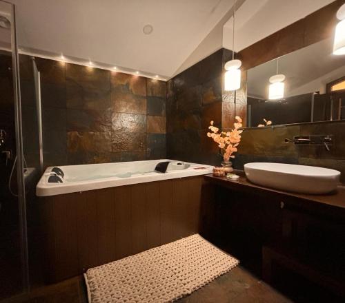 W łazience znajduje się wanna, umywalka i lustro. w obiekcie Monte Do Malhao - Art, Eco & Spa w mieście Castro Marim