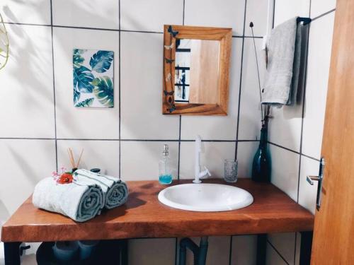ein Bad mit einem Waschbecken und einem Spiegel in der Unterkunft Rosa dos Ventos Chalés in Cavalcante