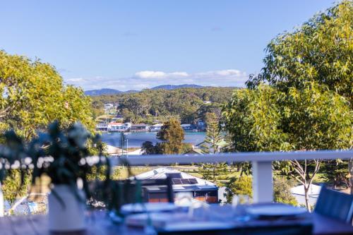 a balcony with a view of a river and trees at Chilltown Burrill Lake in Burrill Lake