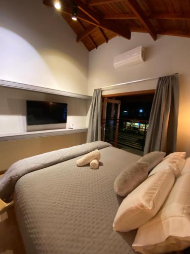 um quarto com uma cama com um urso de peluche em Apartamento Avenida em Camanducaia