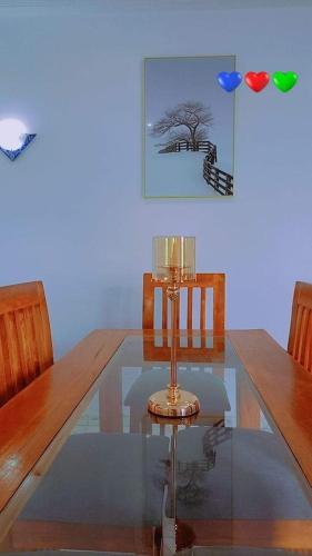 uma mesa de vidro com duas cadeiras e uma árvore em Timba chic-Allada em Allada