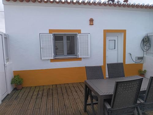 une chambre avec une table, des chaises et une fenêtre dans l'établissement Sunny Aljezur da Viana, (Aljezur, Costa Vicentina), à Aljezur