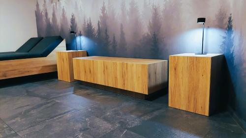 a room with a bed and two wooden tables at TEMPFER 2 Apartments & Rooms with new WELLNESS in Kranjska Gora