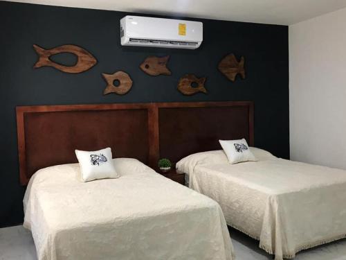- une chambre avec 2 lits et la climatisation murale dans l'établissement Coco’s Beach, à Sisal