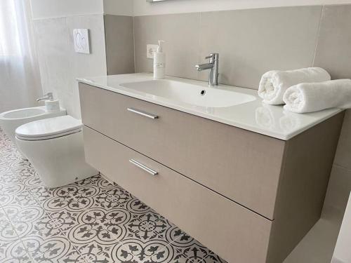 een witte badkamer met een wastafel en een toilet bij Casa Marconi - City Center in Bra