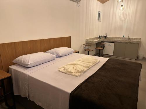 a bedroom with a large bed with white sheets at CORAÇÃO DO ALTO CHALES in Alto Caparao