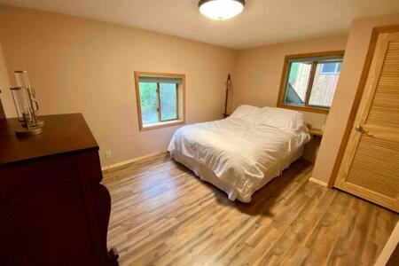タルキートナにあるLazy Bear Retreat at Talkeetna Lodgeのベッドと木の床のある寝室