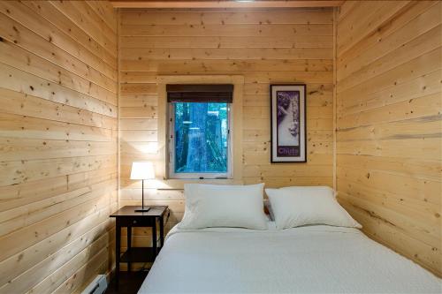 a bed in a wooden room with a window at 74sl - Pets Ok - Wifi - Bbq - Sleeps 8 in Glacier