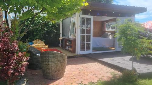 een kleine kamer met een bed in een tuin bij Delightful 1 bedroom tiny house, with retro Poptop in Westport