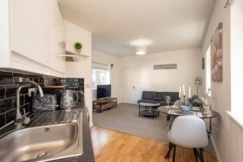 een keuken en een woonkamer met een wastafel en een tafel bij Watford Central Serviced Apartments 2 in Watford