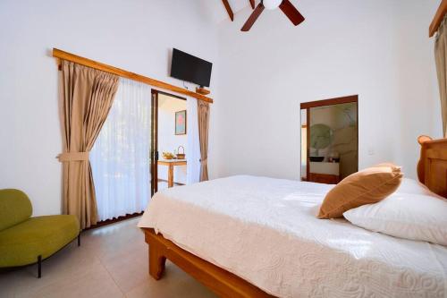 a bedroom with a bed and a television on the wall at Casa Jeffrey - Beach Escape, Stunning views, Private Pool Steps to Ocean in Puerto Viejo