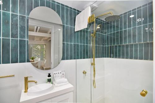 a bathroom with a shower and a sink and a mirror at Palm Cove Retreat in Umina