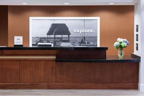 a reception desk with a picture of the ocean at Hampton Inn Fort Lauderdale Downtown Las Olas Area in Fort Lauderdale
