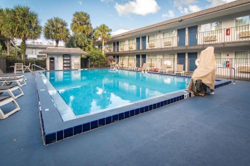 a large swimming pool in front of a hotel at Motel 6-Kissimmee, FL - Orlando in Orlando