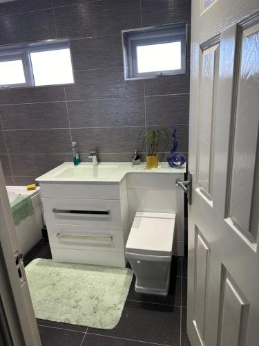 a bathroom with a white toilet and a sink at Double Room in a cosy house in Pitsea in Pitsea