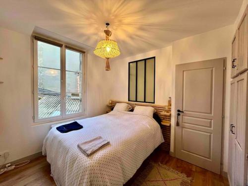une chambre avec un lit, une fenêtre et un lustre dans l'établissement Cosy appartement Bordeaux centre, à Bordeaux