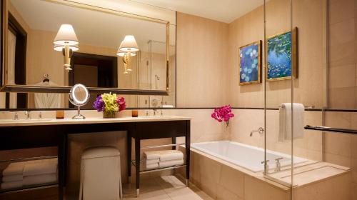 a bathroom with a tub and a large mirror at Encore at Wynn Las Vegas in Las Vegas