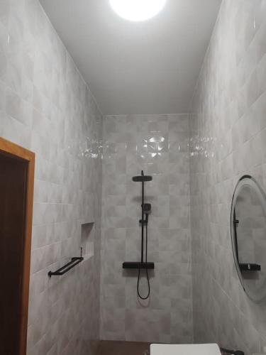 ein Bad mit einer Dusche, einem WC und einem Spiegel in der Unterkunft Le Leo Lodge in Lomé
