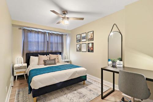 Stickney2BR Midway Getaway! l 20 min to downtown Chicago的卧室里有一张床、一张书桌和一面镜子